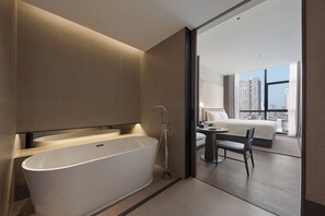 A modern bathroom with a freestanding bathtub, a shower, and a large window offering a city view. - K·SPACE Hotel - Guangzhou Beijing Road Dafo Ancient Temple Branch (Guangzhou)