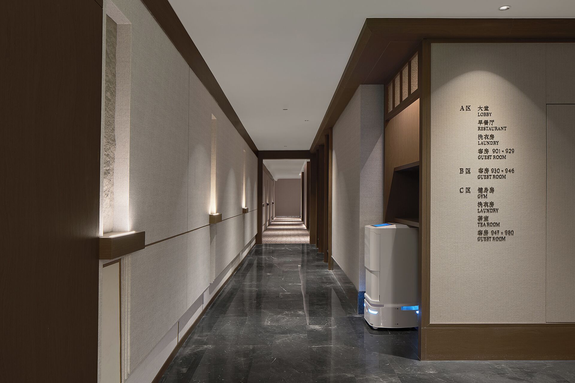 A hotel corridor with a clear layout of guest rooms and amenities.