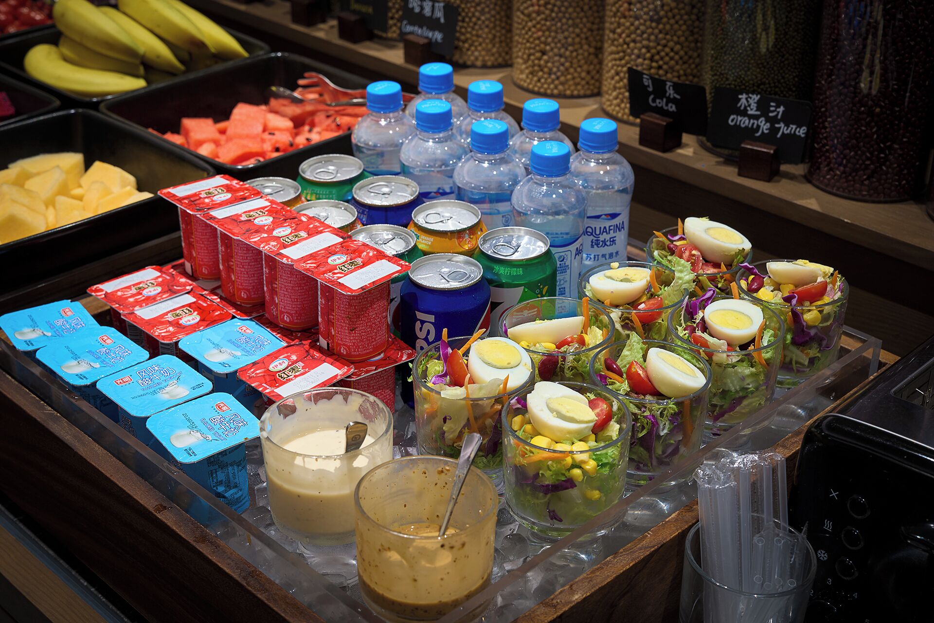 A buffet with various food items, beverages, and condiments.