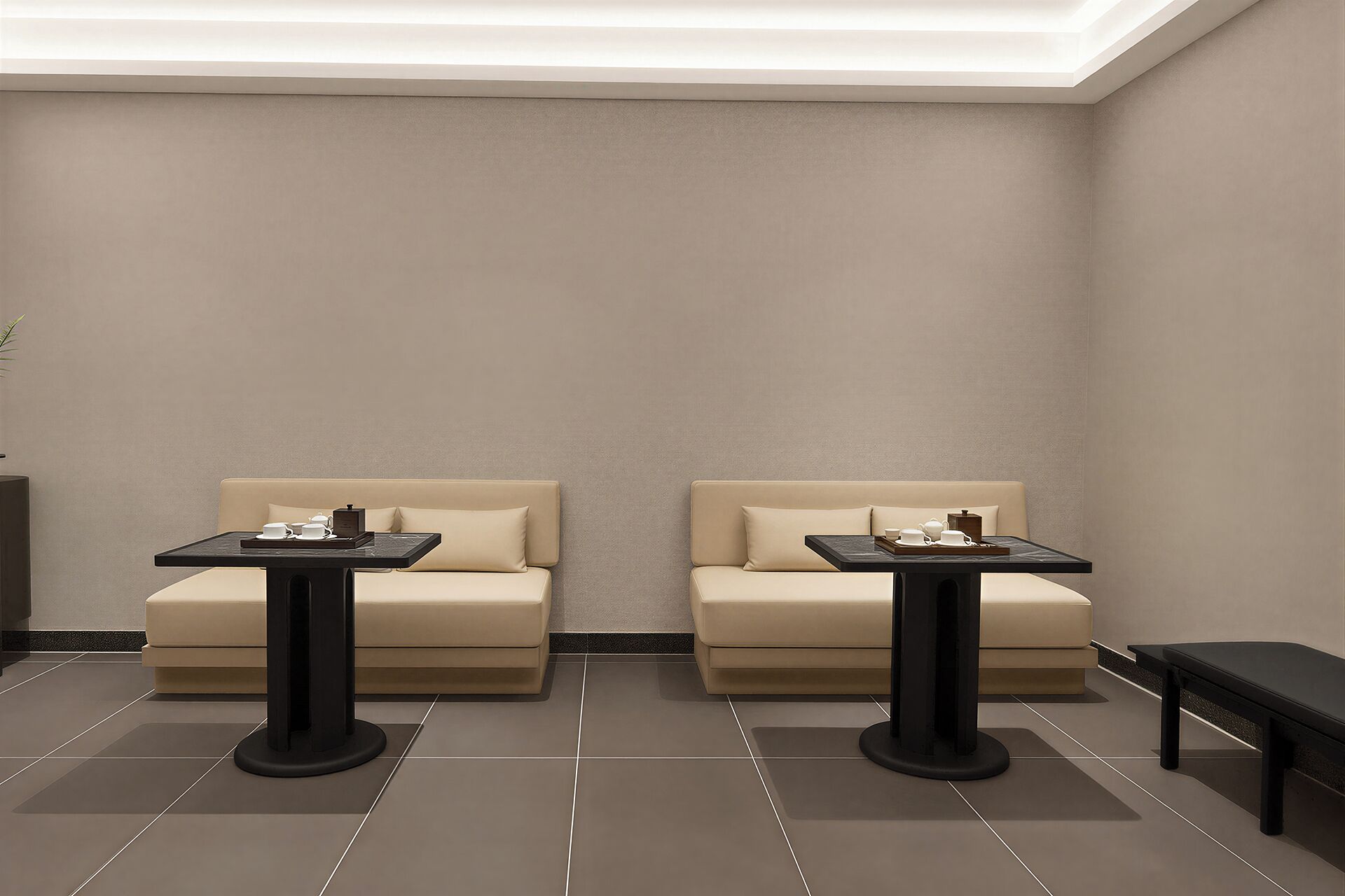 A modern, minimalist room with two sofas and two matching tables, each with a tray of tea and cups.