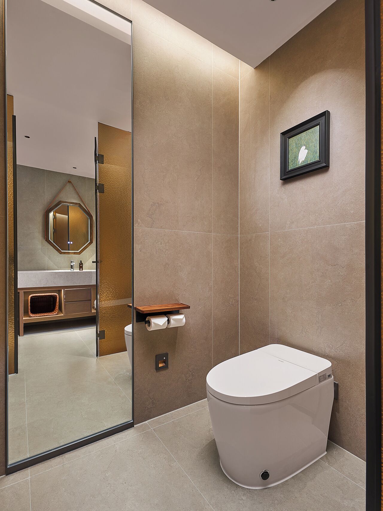 A modern bathroom with a toilet, a sink, and a mirror.