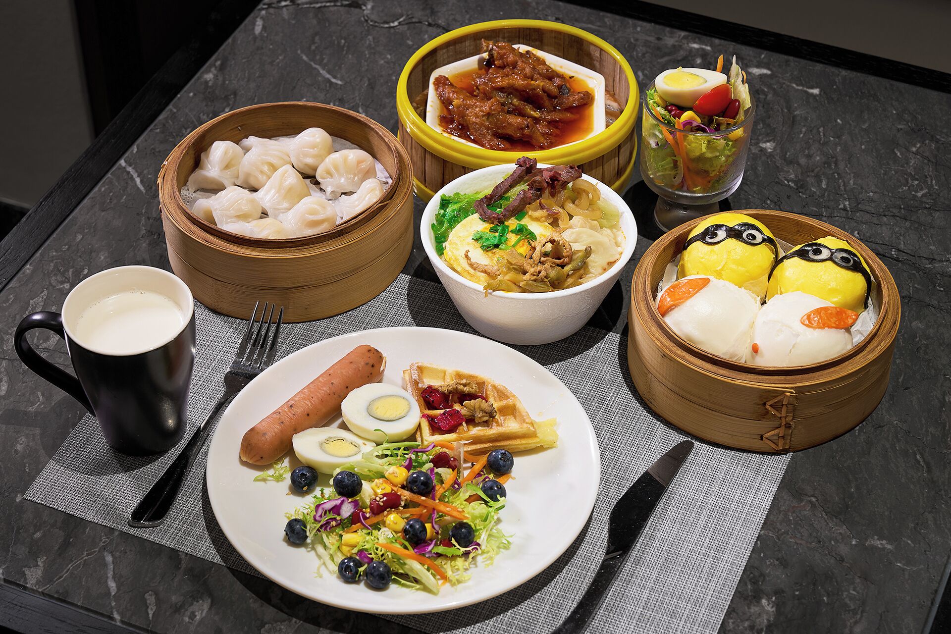 A table with various dishes including dumplings, a salad, and a hot dog.