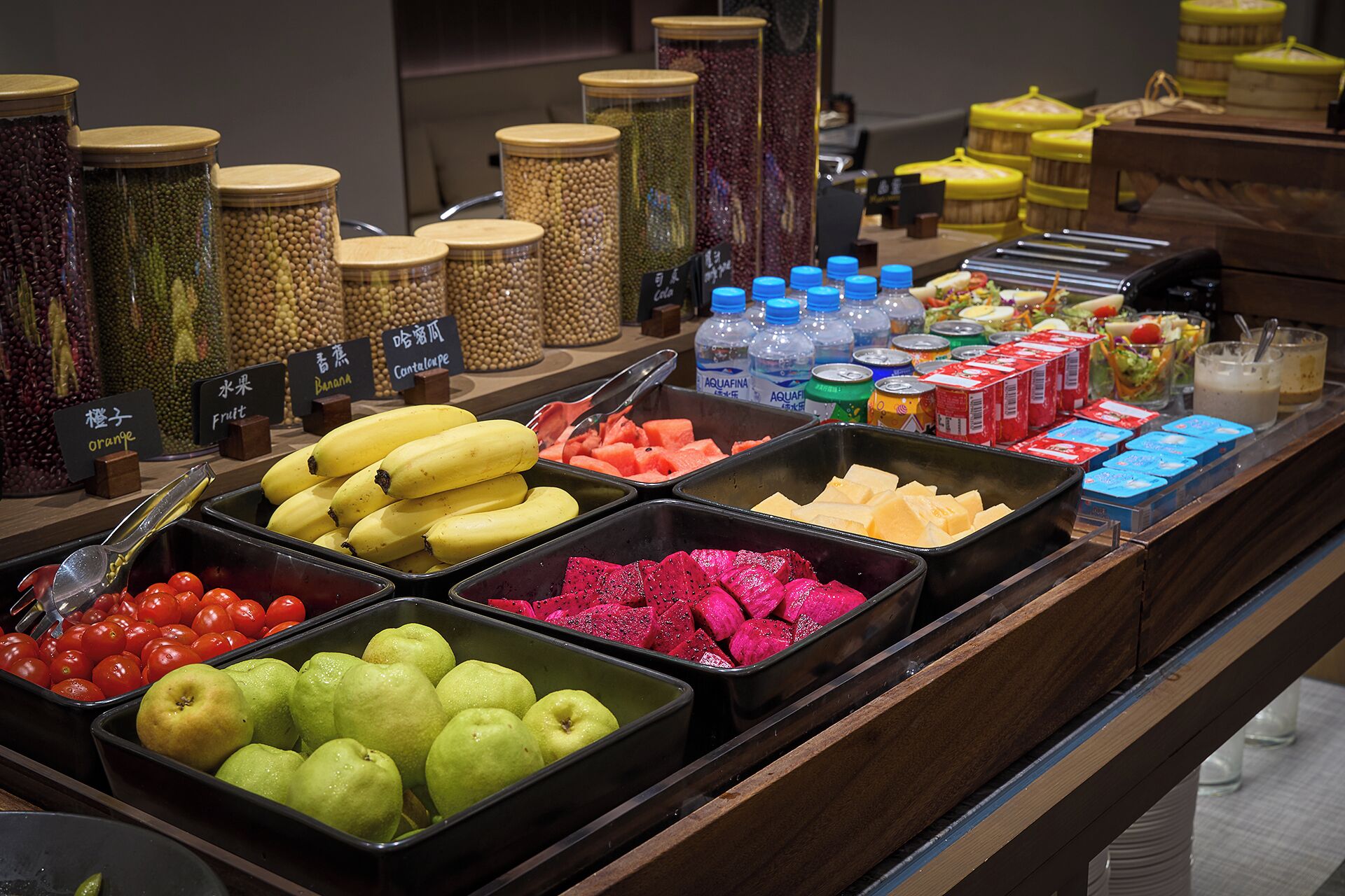 A buffet with various fruits, vegetables, and beverages.