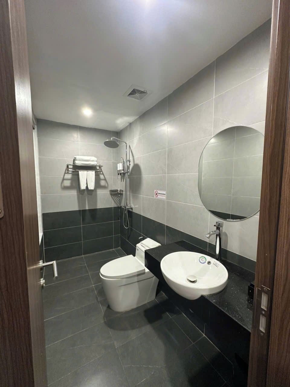 A modern bathroom with a toilet, sink, and shower.