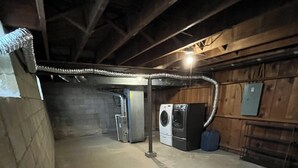 A basement with a washing machine, dryer, and a utility room with a water heater. - Beautiful 2-bedroom apartment with AC in vibrant Columbus (Columbus)