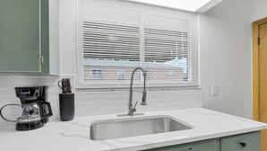 A kitchen with a white countertop, a stainless steel sink, and a window with blinds. - Beautiful 2-bedroom apartment with AC in vibrant Columbus (Columbus)