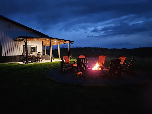 A covered patio with outdoor seating and a fire pit.