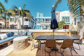 An outdoor patio with a sofa, chairs, and a table. - Walk to Mission Beach: Centrally Located Townhome (San Diego)