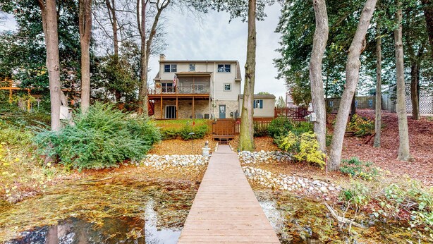 A two-story building with a wooden deck leading to a pond. - Salisbury Waterfront: Schumaker Pond Paradise! (Salisbury)