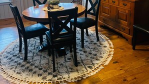 A dining area with a round table, four chairs, a ceiling fan, and a wooden cabinet with shelves. - Waterfront 1860s Farmhouse, Private Hot Tub, Fire Pit, Pond, Canoe, Walk to Town (Chestertown)