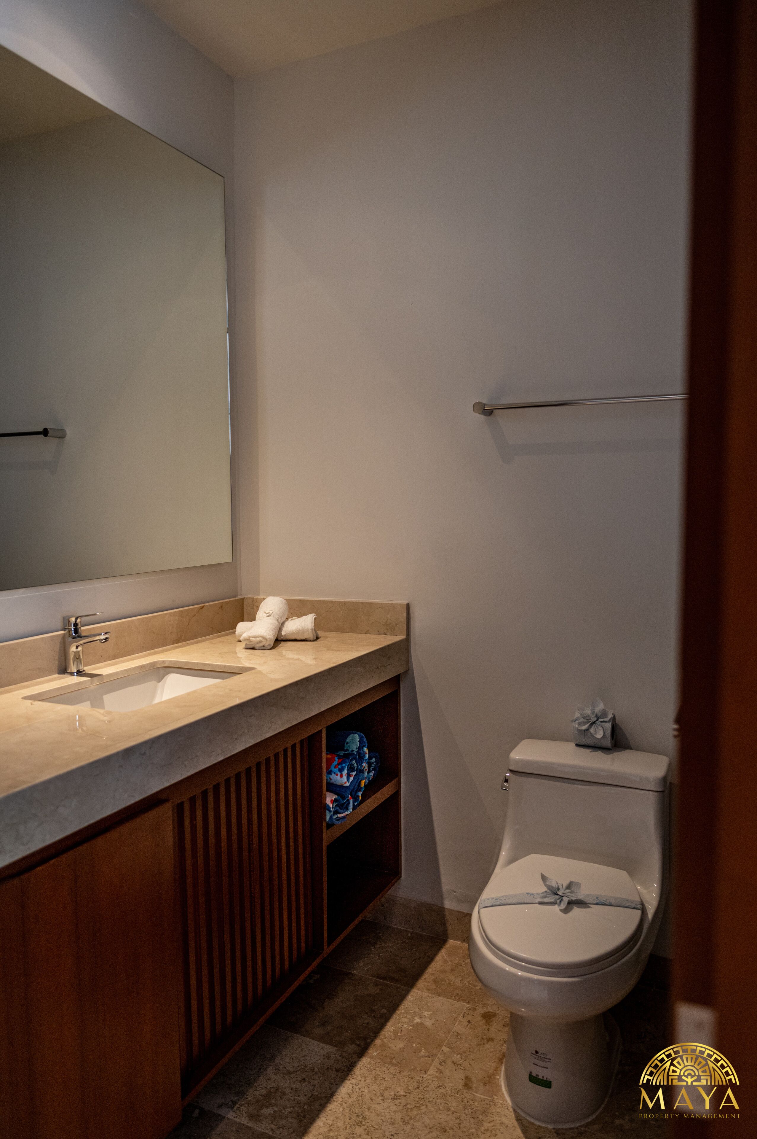 Un baño con lavamanos, espejo e inodoro.