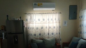 A compact living space with a kitchenette, a sofa, a smaller couch, and a patterned rug. - 2 bedroom apartment with AC inDangriga (Dangriga)