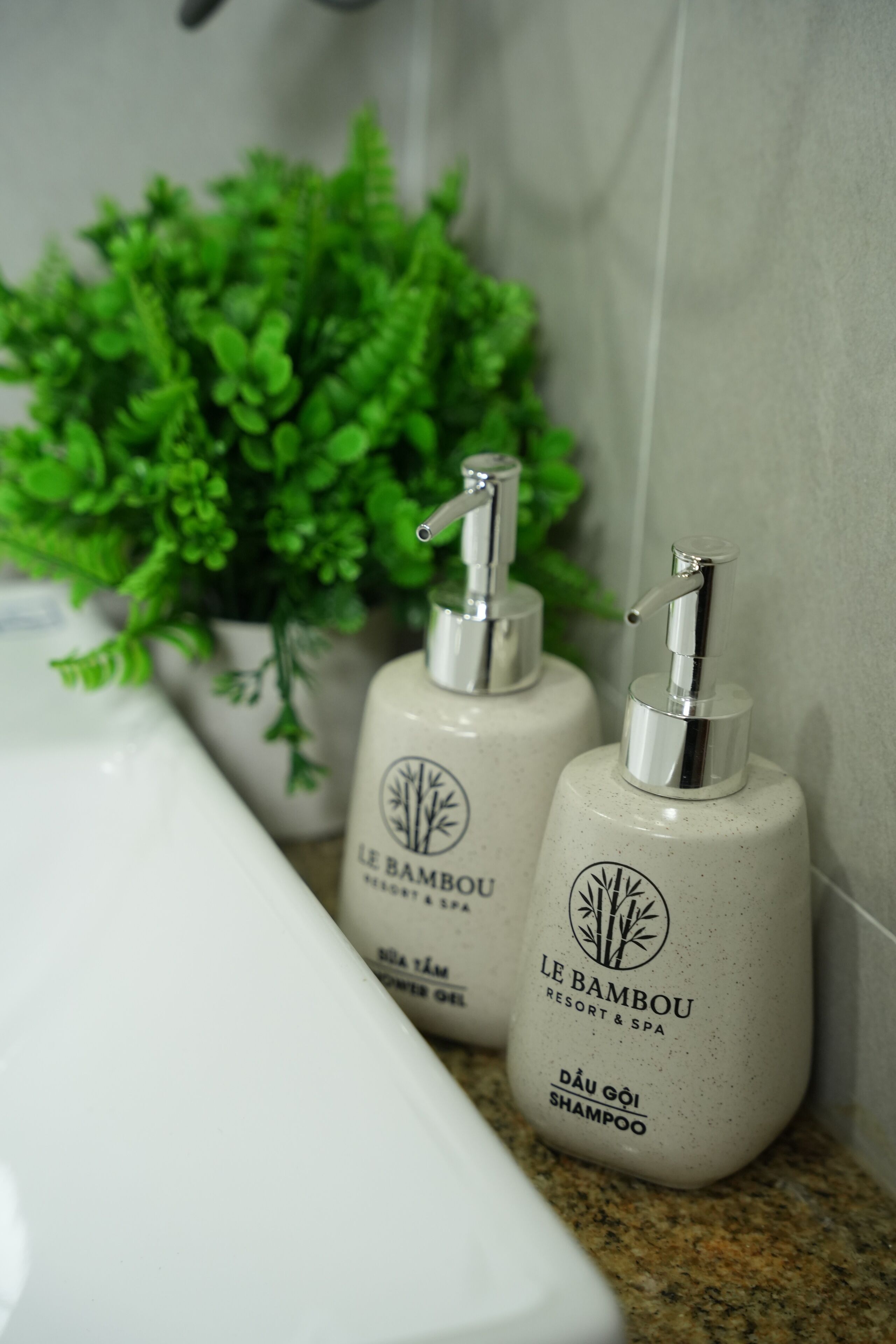 Two bottles of Le Bambou shampoo on a bathroom counter.