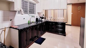 A modern kitchen with white cabinets, a black marble countertop, and a built-in island. - EA1 Studio Apartment Room near SM City Davao Costal Road & Ecoland Bus Terminal (Davao City)