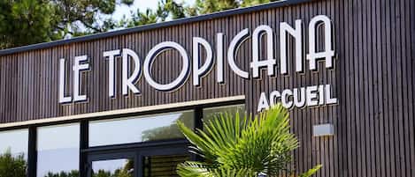 A building with a sign that reads "LE TROPICANA ACCUEIL".