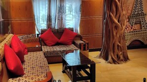 A room with a sofa, a table, and a large tree sculpture.