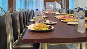 A conference room with a long table, chairs, and food.