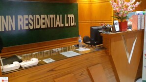 A reception desk with a sign reading 'INN RESIDENTIAL LTD.' and a display of airplane models.