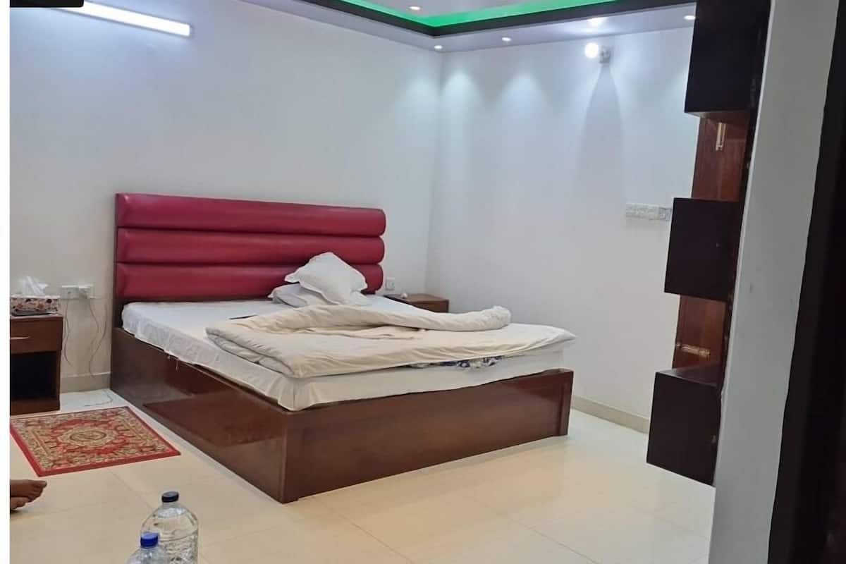 A bedroom with a bed, bedside table, and a nightstand.