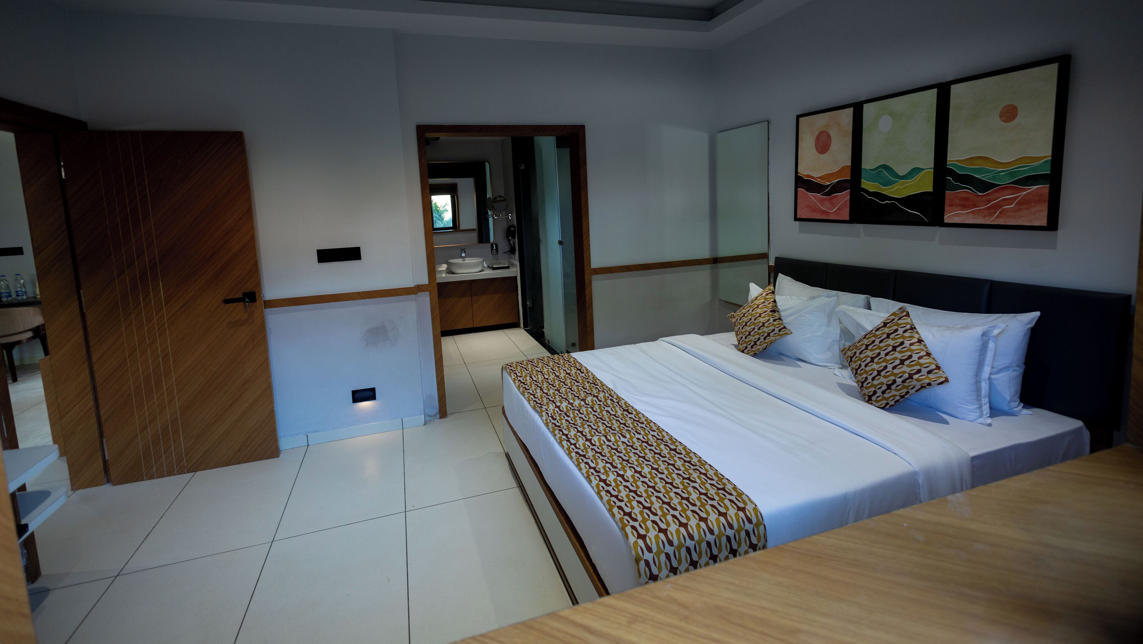 Una habitación de hotel con cama, baño y pasillo.