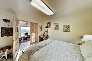 A bedroom with a bed, a desk, a chair, a lamp, and a door leading to a balcony. - Mtn-View Retreat w/ Hot Tub + Deck in Sebastopol (Sebastopol)