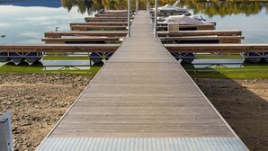 Un muelle de madera que se adentra en aguas tranquilas, con barcos amarrados a ambos lados.