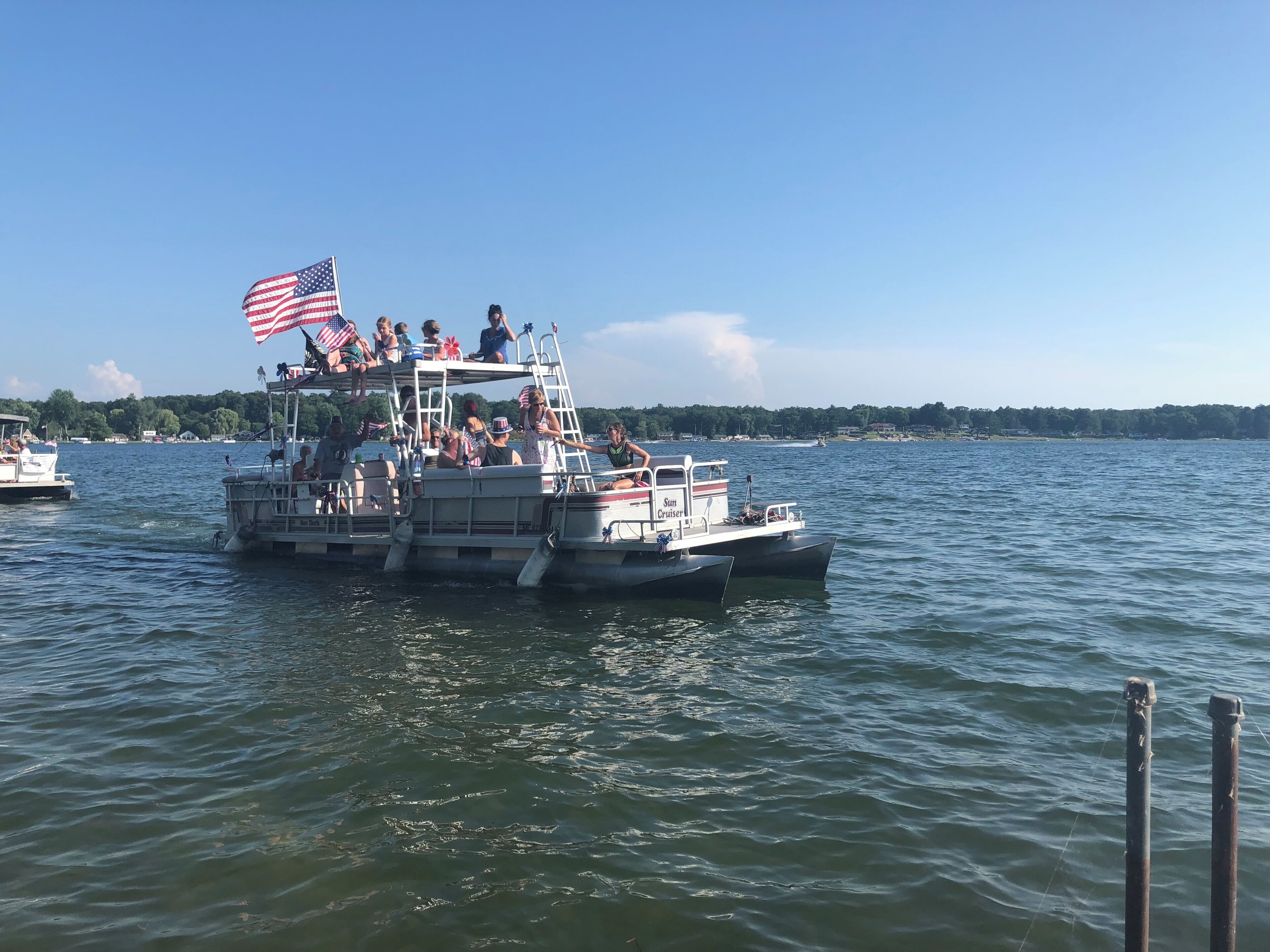 A boat with multiple levels, equipped with seating and a ladder, floating on a body of water.
