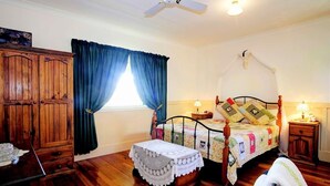 A bedroom with a wooden wardrobe, a four-poster bed, a nightstand, and a window with curtains. - Ashmar offers  you a  true country lifestyle.. (Gloucester)