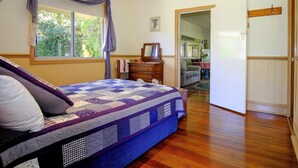A bedroom with a large bed, wooden flooring, a dresser, and a window with curtains. - Ashmar offers  you a  true country lifestyle.. (Gloucester)
