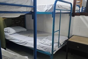 Habitación con literas, una mesita pequeña y un espejo.