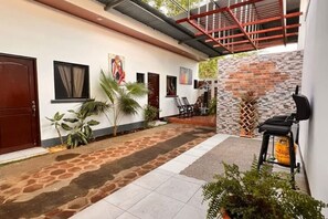 A courtyard with a stone pathway, a red metal staircase, and a brick wall. - Tierra Viva Managua - Villa of rest and nature (Managua)