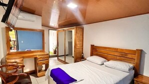 Une chambre à coucher avec un lit en bois, un bureau et une chaise.