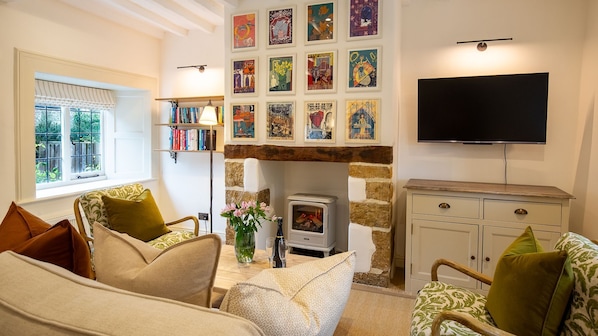 A cozy living room with a fireplace, a television, and a bookshelf. - Oak Cottage - Pet friendly, Swerford (Swerford)
