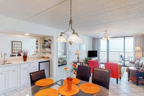 Ein modernes Wohnzimmer mit Essbereich, einer Küche und einem Balkon mit Blick.