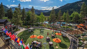 A resort with outdoor seating, a pool, and mountains in the background. - Everline Resort Studio w/ Luxury Resort Perks (Olympic Valley)
