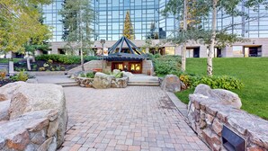 A courtyard with a stone pathway leading to a building with a glass facade. - Everline Resort Studio w/ Luxury Resort Perks (Olympic Valley)