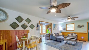 Un espacio habitable amplio con una mesa de comedor, sillas, un sofá y un ventilador de techo.