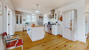 A spacious kitchen with wooden flooring, white cabinetry, and a central island. - Close to Copake Lake! 4-Season Escape w/ Sauna (Copake)