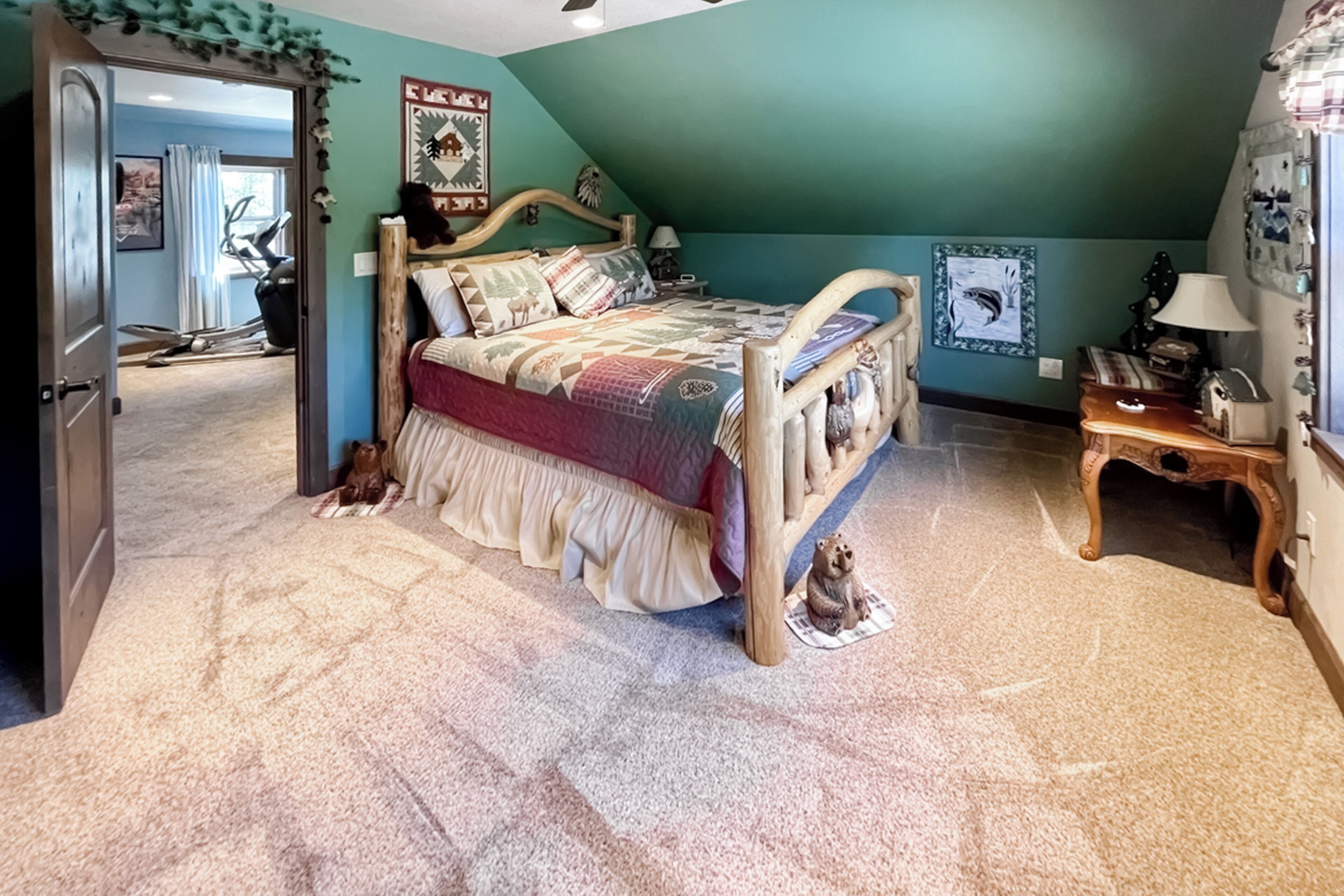 Un dormitorio con una cama de madera, una mesita y una silla.