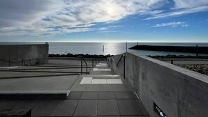 A rooftop terrace with a view of the sea, a concrete wall, and a metal railing. - Mimosa 2 bedrooms 33m² + TV 4 persons (ST PIERRE D OLERON)