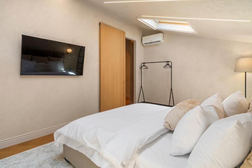 Una camera da letto con un letto, una TV a parete, un armadio e un condizionatore d'aria.