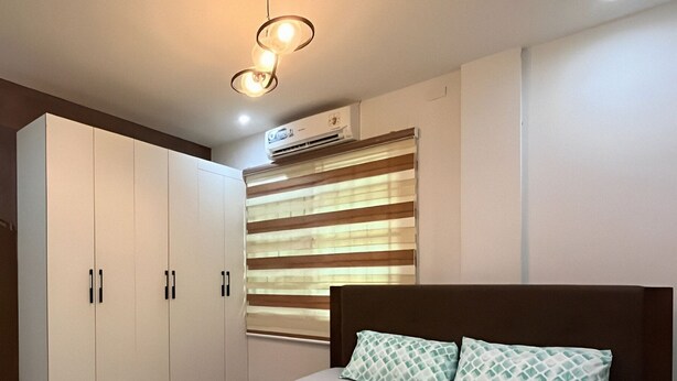 A bedroom with a bed, a wardrobe, and a window with blinds. - Ranchotel Guesthouse in Villasis (Villasis)