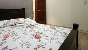 A bedroom with a bed, a wooden door, and a light switch on the wall. - Ranchotel Guesthouse in Villasis (Villasis)