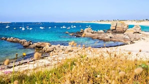 A coastal landscape with clear blue waters, rocky formations, and boats. - Select TV LV Wi-Fi Plancha Mobile Home - 2 bedrooms - 4 people (JUGON LES LACS)