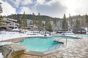 A swimming pool with a stone deck, surrounded by snow-covered ground and trees. - Everline Suite w/ Resort Perks! 7 Mi to Lake Tahoe (Olympic Valley)