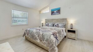 A bedroom with a bed, a nightstand, a ceiling fan, a window with blinds, and a painting on the wall. - Steps to Sea! Coastal Escape in Fort Walton Beach (Fort Walton Beach)