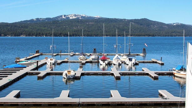 A marina with boats docked at wooden piers, surrounded by calm water and a forested mountain range in the background. - Home w/ Hot Tub, 3 Mi to Lake & Ponderosa Park (McCall)