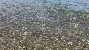 Una vista chiara di una costa rocciosa con acque basse.