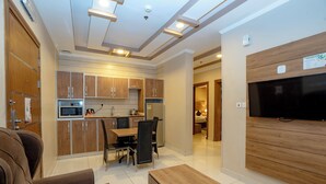 A modern living room with a sofa, a coffee table, and a TV mounted on the wall. - MG Crown Hotel 4 (Madinah)