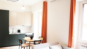 Um espaço compacto com cozinha americana, área de refeições e sofá.